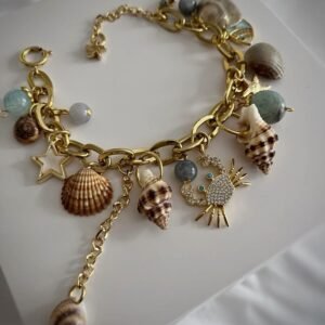 a gold bracelet with seashells and charms