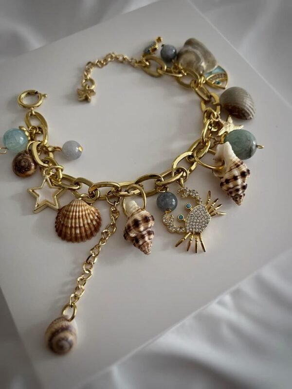a gold bracelet with seashells and charms