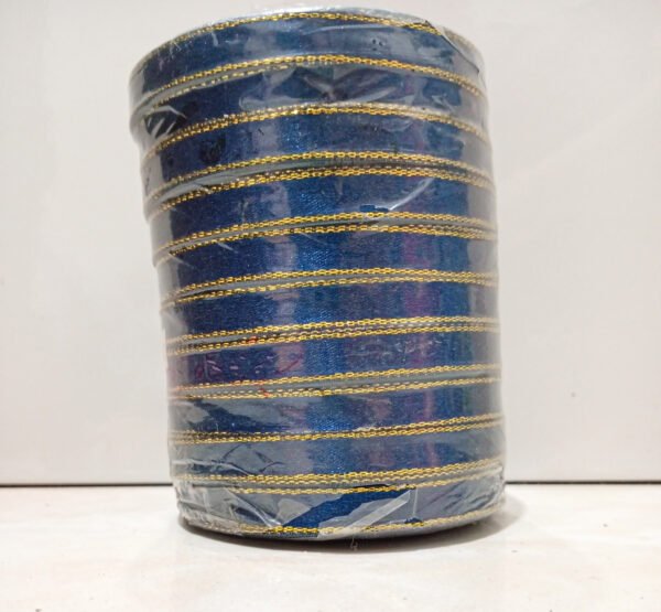 A cylindrical blue container wrapped with shiny gold diagonal lines, placed on a light surface against a plain background.